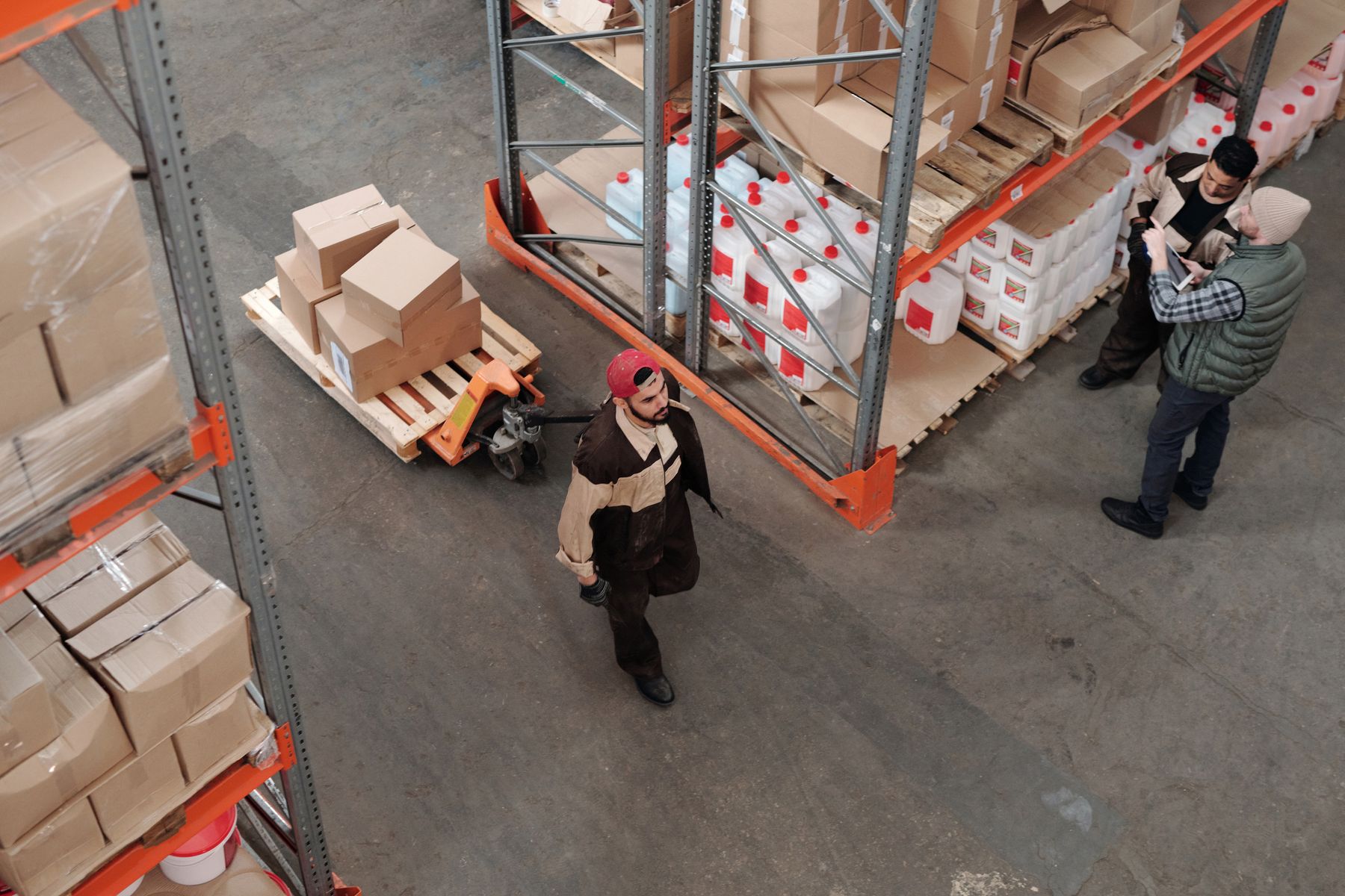 Warehouse team picking cardboard cartons beside storage racks